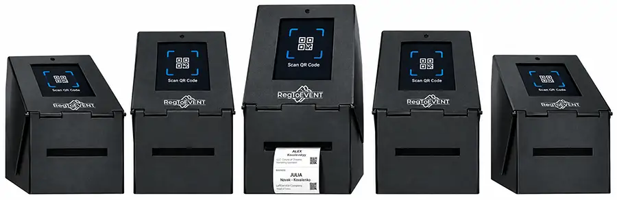 Пять стоек саморегистрации Чекинбокс в ряд: на экранах приглашение «Scan QR Code», из центральной стойки выходит напечатанный бейдж участника